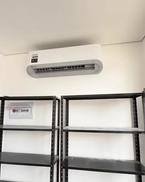 Split Electrolux instalado em sala comercial com estantes de aço