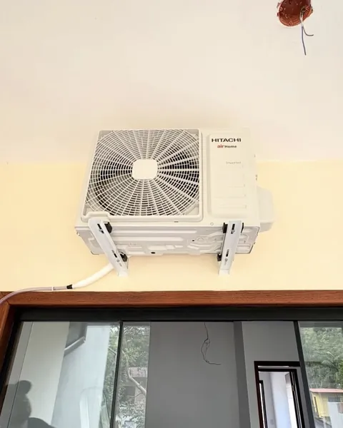 Condensadora Hitachi instalada em suportes acima de uma porta de vidro
